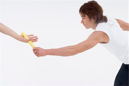 runner side view white background - Young man giving relay baton Stock Photo - Premium Royalty-Free, Code: 685-02941786