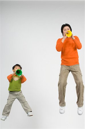 Father and son cheering with megaphone Stock Photo - Premium Royalty-Free, Code: 685-02942035