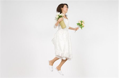 full body white background apron - Young woman holding flower Stock Photo - Premium Royalty-Free, Code: 685-02942048