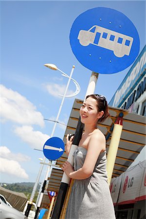 people at bus stop - Young woman standing at bus stop Foto de stock - Sin royalties Premium, Código: 685-03081587