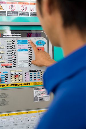 Gas station clerk operating machine Stock Photo - Premium Royalty-Free, Code: 685-03081728