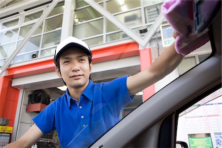 Gas station clerk wiping car window Stock Photo - Premium Royalty-Free, Code: 685-03081735