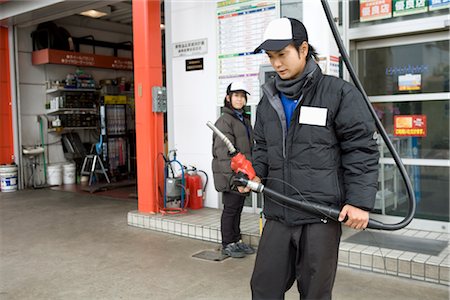 Gas station clerk holding nozzle Stock Photo - Premium Royalty-Free, Code: 685-03081761