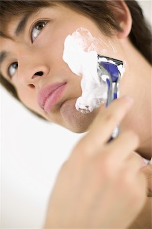 espuma de afeitar - Young man shaving Foto de stock - Sin royalties Premium, Código: 685-03081881