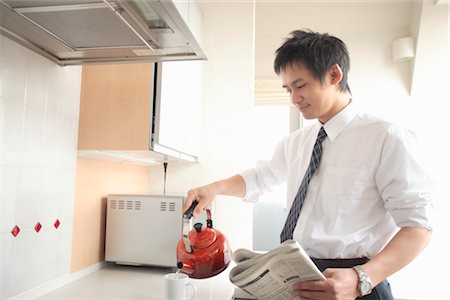 Businessman holding kettle in kitchen Foto de stock - Sin royalties Premium, Código: 685-03082333