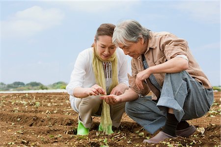 Senior couple squatting on field Stock Photo - Premium Royalty-Free, Code: 685-03082613