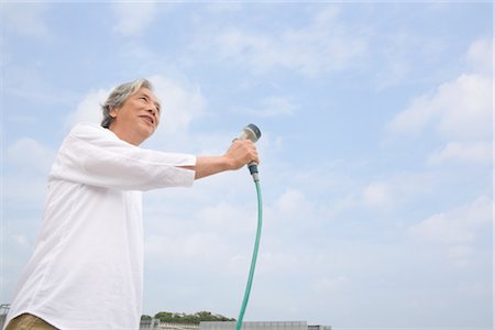 Senior man watering veranda Stock Photo - Premium Royalty-Free, Code: 685-03082669