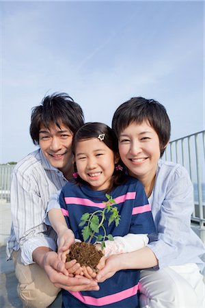 Parents and daughter holding seedling Stock Photo - Premium Royalty-Free, Code: 685-03082739