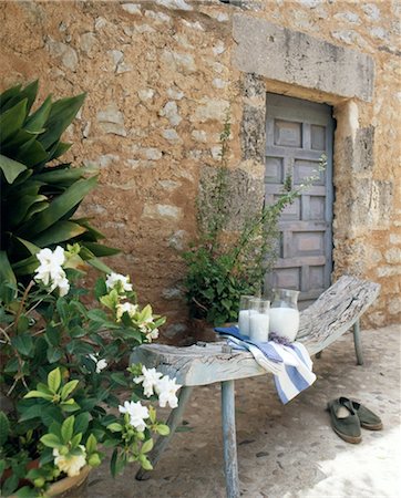 Wooden bench with carafe of milk in front of stone house Foto de stock - Sin royalties Premium, Código: 689-05610391