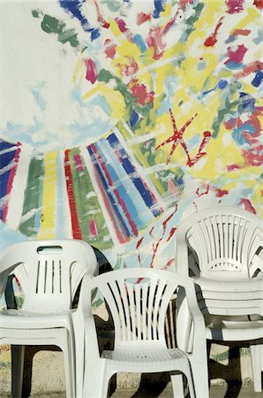 simsearch:689-05610321,k - Plastic chairs in front of painted building facade Foto de stock - Royalty Free Premium, Número: 689-05610423