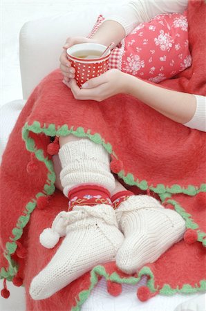 Woman wearing woolen socks lying on couch with cup of tea Stock Photo - Premium Royalty-Free, Code: 689-05610443