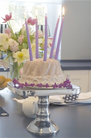 Gâteau d'anniversaire avec des bougies et bouquet de fleurs sur la table Photographie de stock - Premium Libres de Droits, Code: 689-05610618