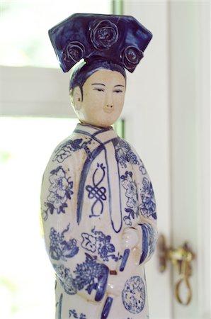 Asian figurine in front of window Stock Photo - Premium Royalty-Free, Code: 689-05611416