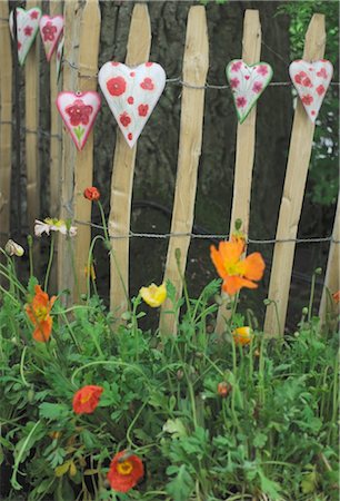 Hearts an flowers at wooden fence in garden Stock Photo - Premium Royalty-Free, Code: 689-05611431