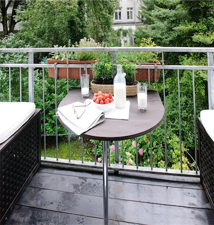 Milk, strawberries, eyeglasses and newspaper on balcony table Stock Photo - Premium Royalty-Free, Code: 689-05611807