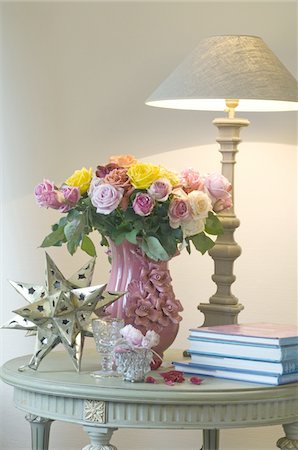 Bouquet de fleurs, lampe de table, étoiles décoratives et livres sur la table Photographie de stock - Premium Libres de Droits, Code: 689-05611831