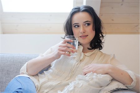 Junge Frau auf Couch Glas Wasser trinken Stockbilder - Premium RF Lizenzfrei, Bildnummer: 689-05611947