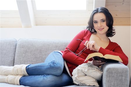 Young woman reading book on couch Stock Photo - Premium Royalty-Free, Code: 689-05611959