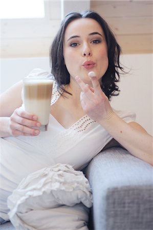 simsearch:689-05612237,k - Young woman on couch drinking Latte Macchiato Stock Photo - Premium Royalty-Free, Code: 689-05611950