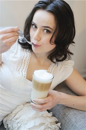 Young woman on couch drinking Latte Macchiato Foto de stock - Sin royalties Premium, Código: 689-05611951