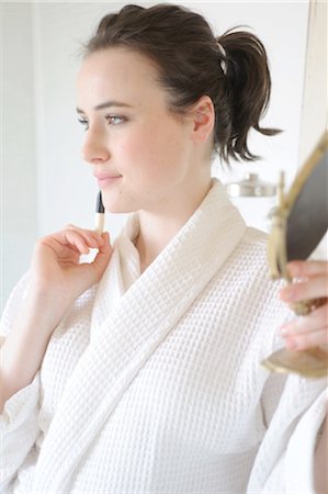 Young woman applying blush in bathroom Stock Photo - Premium Royalty-Free, Code: 689-05611982