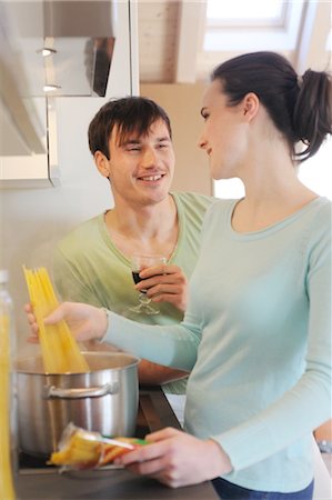 simsearch:689-05612723,k - Young couple in kitchen cooking spaghetti and drinking red wine Foto de stock - Sin royalties Premium, Código: 689-05612011