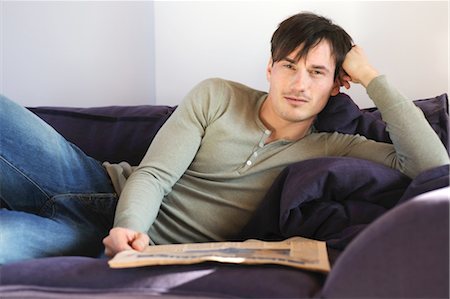 simsearch:689-05611972,k - Young man on couch reading newspaper Stock Photo - Premium Royalty-Free, Code: 689-05612013