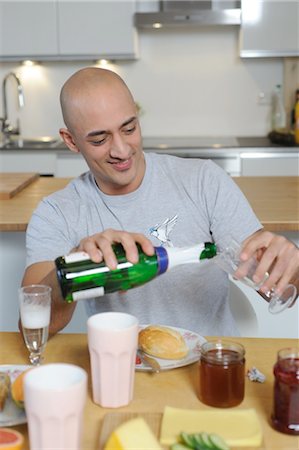picture of champagne bottle and champagne flute - Man in kitchen pouring champagne into glass Stock Photo - Premium Royalty-Free, Code: 689-05612032