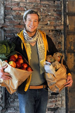 people stand in front brick wall - Man carrying shopping bags with produce Foto de stock - Sin royalties Premium, Código: 689-05612070