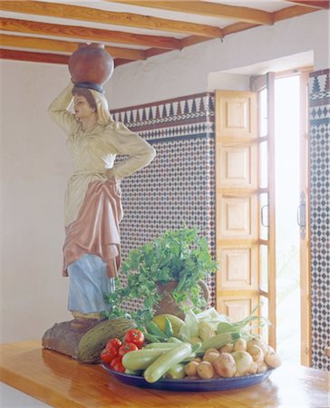 Bowl with vegetable and sculpture on kitchen counter Stock Photo - Premium Royalty-Free, Code: 689-05612230