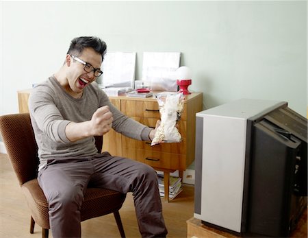 stylish asian man - Cheering man watching TV Stock Photo - Premium Royalty-Free, Code: 689-05612555