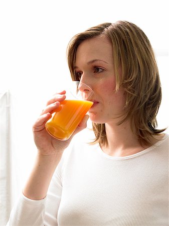 simsearch:689-03124058,k - Woman drinking juice Foto de stock - Sin royalties Premium, Código: 689-03124060
