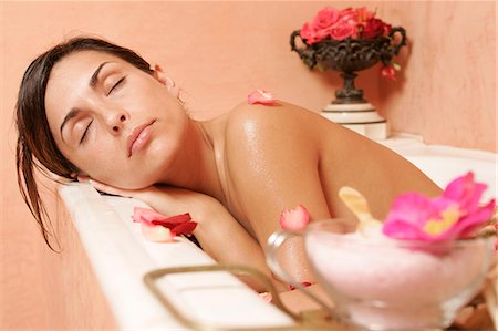 Woman in bath tub with petals,closing her eyes Stock Photo - Premium Royalty-Free, Code: 689-03124164
