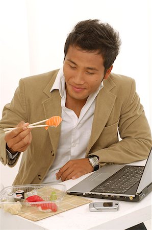 simsearch:689-03124356,k - Asian man is eating sushi on his desk Stock Photo - Premium Royalty-Free, Code: 689-03124555