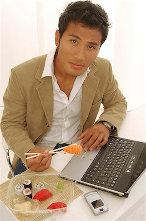simsearch:689-03124356,k - Asian man is eating sushi on his desk Stock Photo - Premium Royalty-Free, Code: 689-03124556