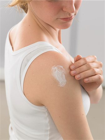 simsearch:689-03123953,k - Woman is putting lotion on her shoulder Stock Photo - Premium Royalty-Free, Code: 689-03124819