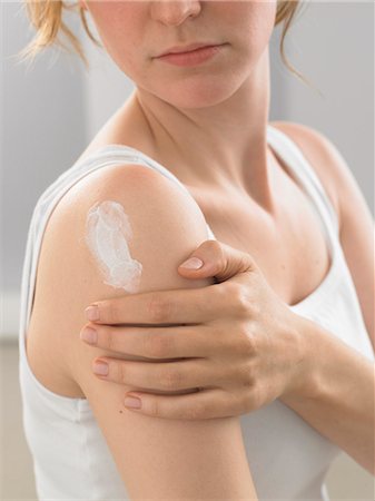 simsearch:689-03123953,k - Woman is putting lotion on her shoulder Stock Photo - Premium Royalty-Free, Code: 689-03124820