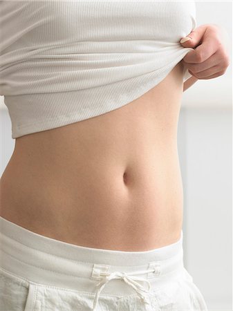 Belly underneath a shirt pulled up Stock Photo - Premium Royalty-Free, Code: 689-03124832