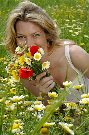 fair people clothing color - Woman is sitting in a meadow with a bunch of flowers Stock Photo - Premium Royalty-Free, Code: 689-03125155