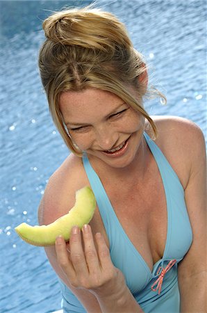 Woman with a piece of sweet melon Stock Photo - Premium Royalty-Free, Code: 689-03125437