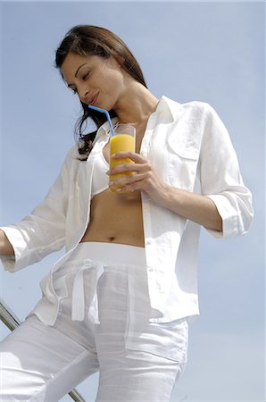 simsearch:689-03124937,k - Woman dressed in white enjoying a drink at the swimming pool Fotografie stock - Premium Royalty-Free, Codice: 689-03125432