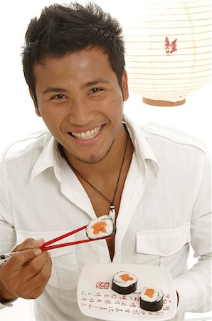 simsearch:689-03124356,k - Asian man is eating sushi with chopsticks Stock Photo - Premium Royalty-Free, Code: 689-03125578
