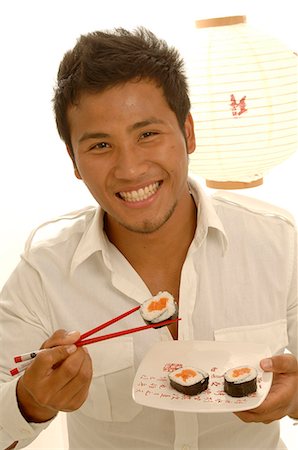 simsearch:689-03124356,k - Man is eating sushi with chopsticks Stock Photo - Premium Royalty-Free, Code: 689-03125579