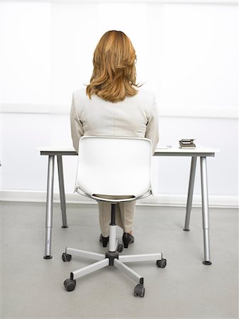 secretary on chair in office - Recul d'une femme d'affaires assis à son bureau Photographie de stock - Premium Libres de Droits, Code: 689-03125886