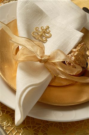 Christmas table place setting,napkin tied with a golden ribbon Stock Photo - Premium Royalty-Free, Code: 689-03126876