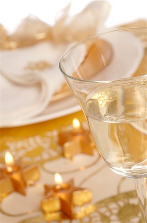 Christmas table place setting,napkin tied with a golden ribbon and a glass of white wine Stock Photo - Premium Royalty-Free, Code: 689-03126878