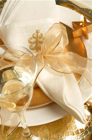 Christmas table place setting,napkin tied with a golden ribbon and a glass of white wine Stock Photo - Premium Royalty-Free, Code: 689-03126873