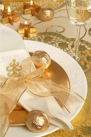 Christmas table place setting,napkin tied with a golden ribbon and golden walnuts Stock Photo - Premium Royalty-Free, Code: 689-03126880