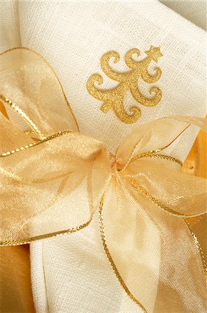 simsearch:689-03126188,k - Napkin with a Christmas tree pattern tied with a golden ribbon Foto de stock - Royalty Free Premium, Número: 689-03126881