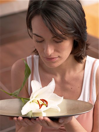 spa model - Woman is holding a bowl with lily blossom Stock Photo - Premium Royalty-Free, Code: 689-03127239